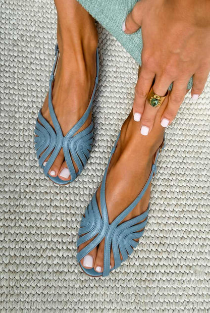 sandales plates d'été noires en cuir à brides style cage et bout ouvert.