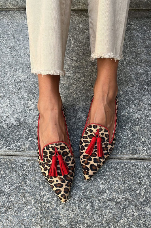 chaussures plates décontractées à bout effilé en suédine léopard et pompons.
