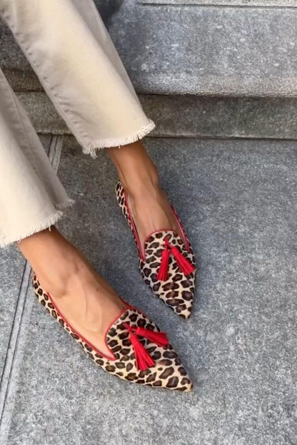 chaussures plates décontractées à bout effilé en suédine léopard et pompons.